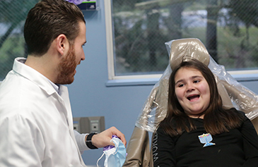 Dr speaking to girl in dental chair