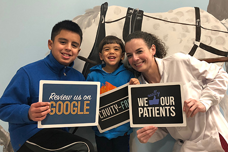Dr. with two patients holding signs